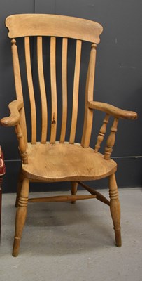 Lot 234 - An antique pine kitchen armchair, 115cm high.