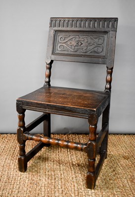 Lot 493 - An 18th century oak chair, the back panel...