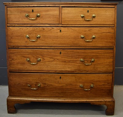 Lot 504 - A Georgian elm chest of drawers, the two short...