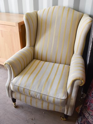 Lot 487 - A modern wingback armchair upholstered in...